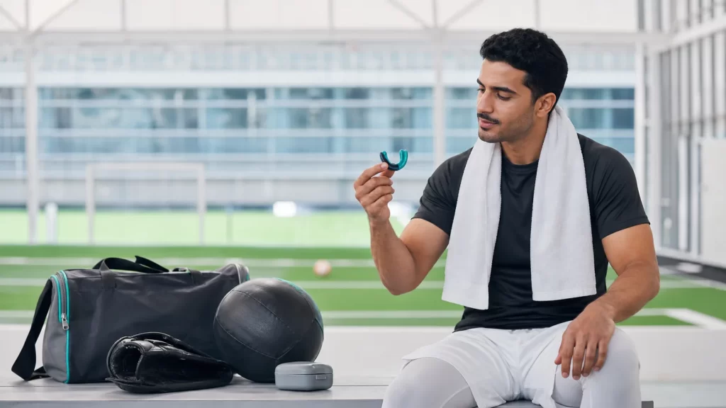 رياضي سعودي يحمل واقي فم مناسبًا مع حفظ قوالب الإنفزلاين في علبتها